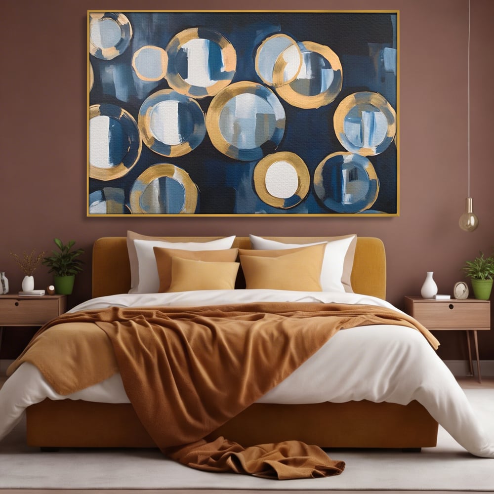 Tablou canvas cu pictura abstracta cu cercuri albastre si aurii, in rama de aluminiu auriu, pe perete intr-un dormitor